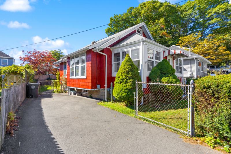 Red cottage with private driveway and fenced front yard